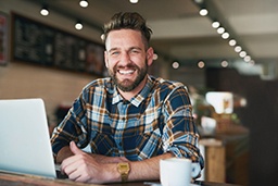 a smiling man sitting in a coffee shop