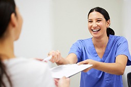 a healthcare worker handing a patient forms