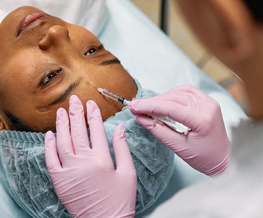 Woman treating frown lines with dermal filler