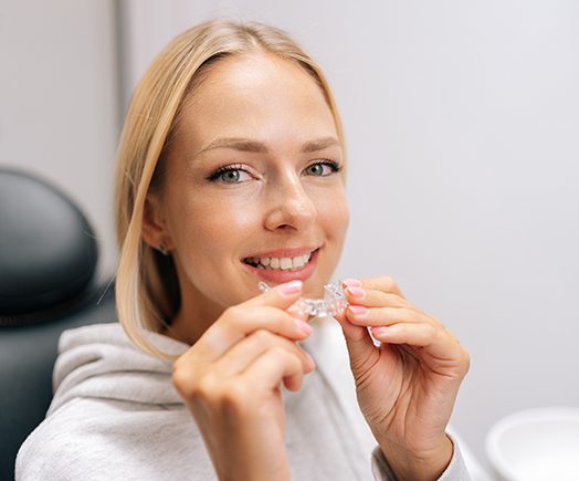 Dental assistant smiling while handing patient form