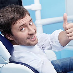 Male dental patient giving a thumbs-up